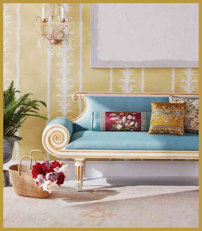 yumuşak sarı duvar kağıdı, zengin, pastel mavi kanepe ve renkli vurgulu yastıklarla kontrast oluşturulmuş.